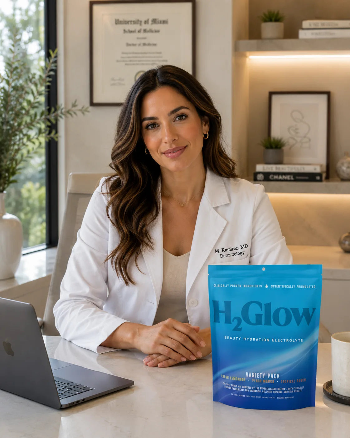 Woman in a white lab coat seated at a desk with a blue H2Glow electrolyte pouch in a clinic office