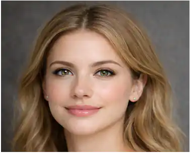 Close-up portrait of a woman with blonde hair, green eyes, and small earrings against a gray backdrop.