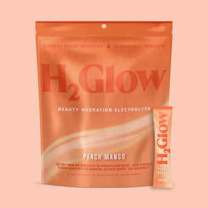 Bright orange H2Glow electrolyte drink variety pack in peach mango flavor, shown with single serving sticks.