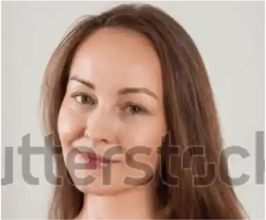 Woman with auburn hair looking to the side, close up portrait against a light background