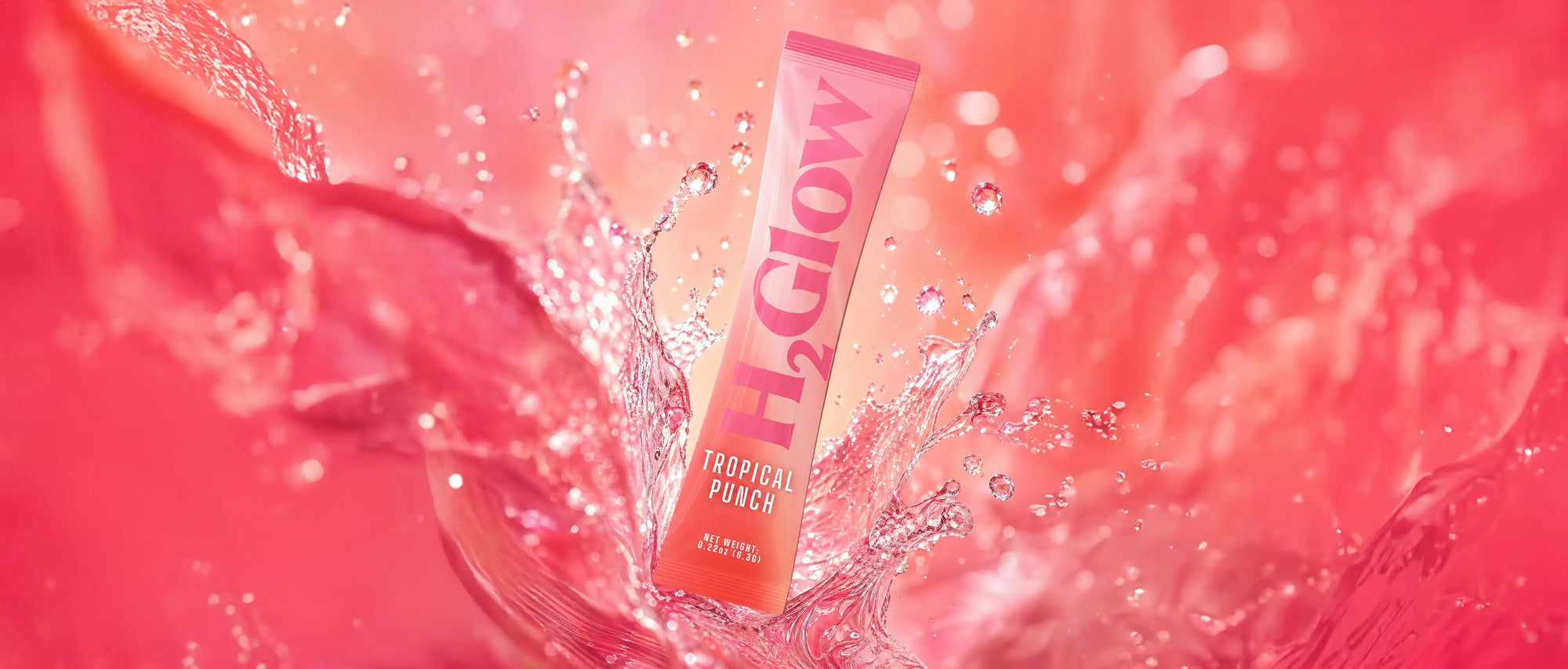 Tropical punch drink pouch standing in splashing red water with bubbles and silver droplets