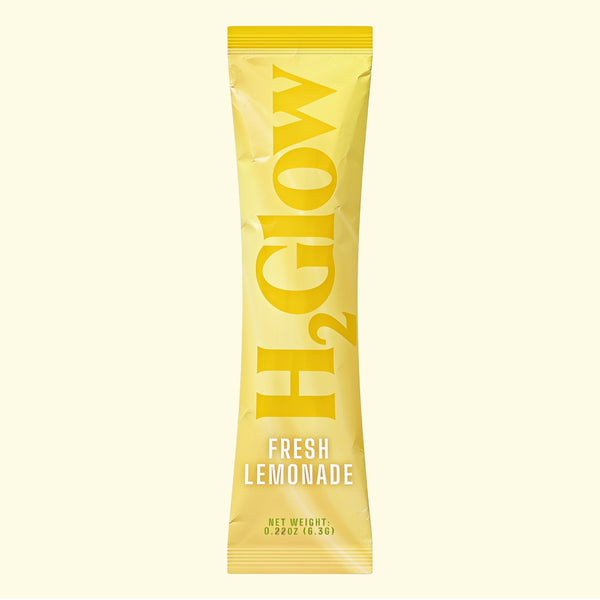 Yellow stick pack with bold “FRESH LEMONADE” lettering and stylized starburst graphic, centered on a cream background.